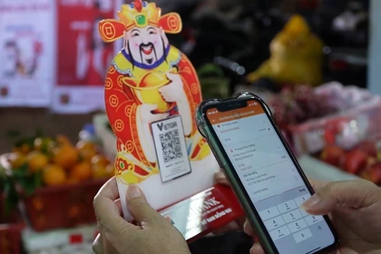 Tấm mã QR nhỏ bên sạp hàng cho thấy thanh toán số trở thành điều bình thường trong đời sống hằng ngày của người dân.