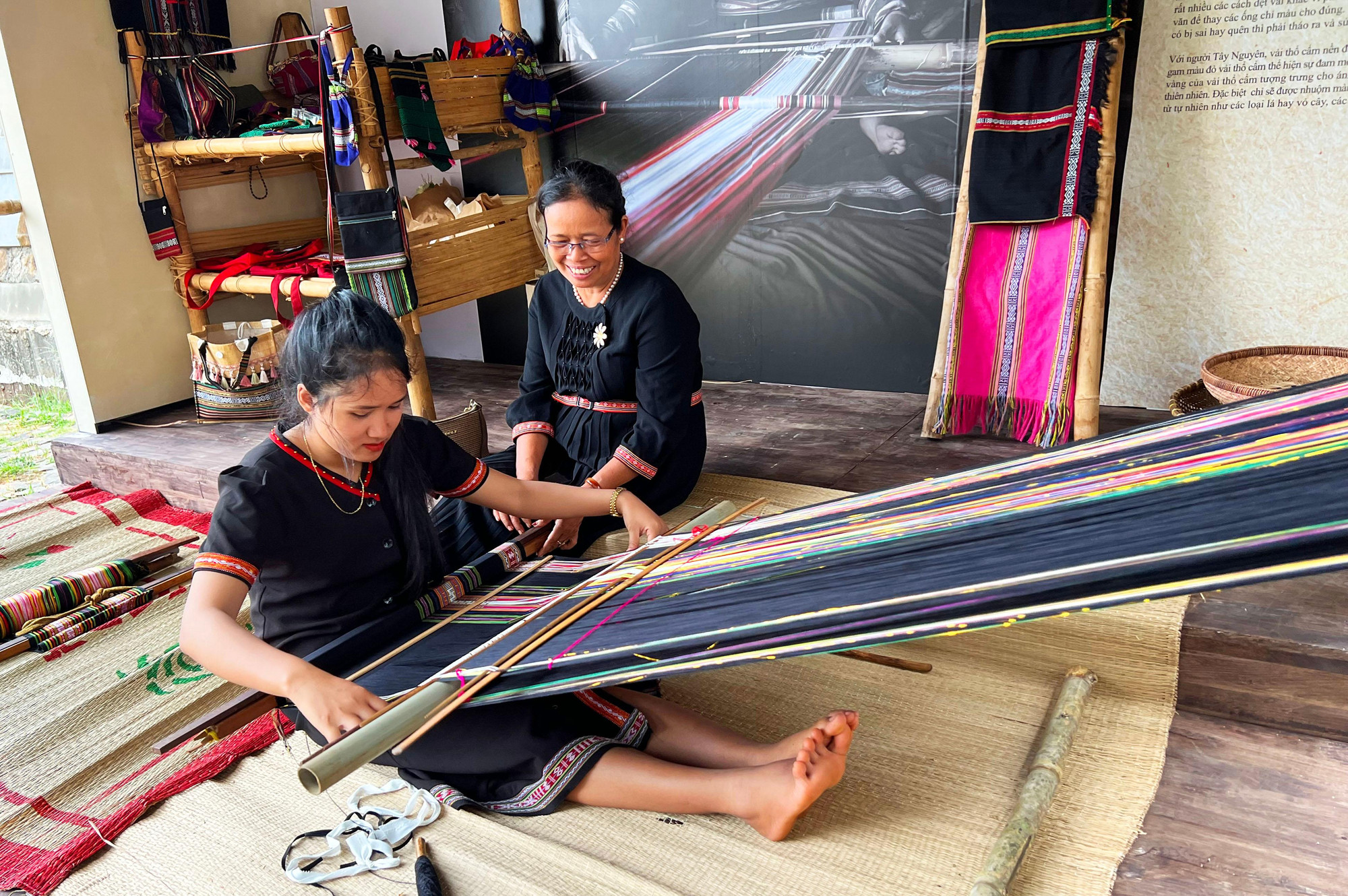 Bà H'Yam BKrông vui vẻ hướng dẫn thiếu nữ dệt thổ cẩm