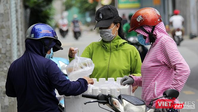 Người dân TP.HCM chia sẻ với nhau những phần cơm từ thiện ngay trên đường phố trong những ngày dịch Covid-19 bùng phát tháng 7/2021