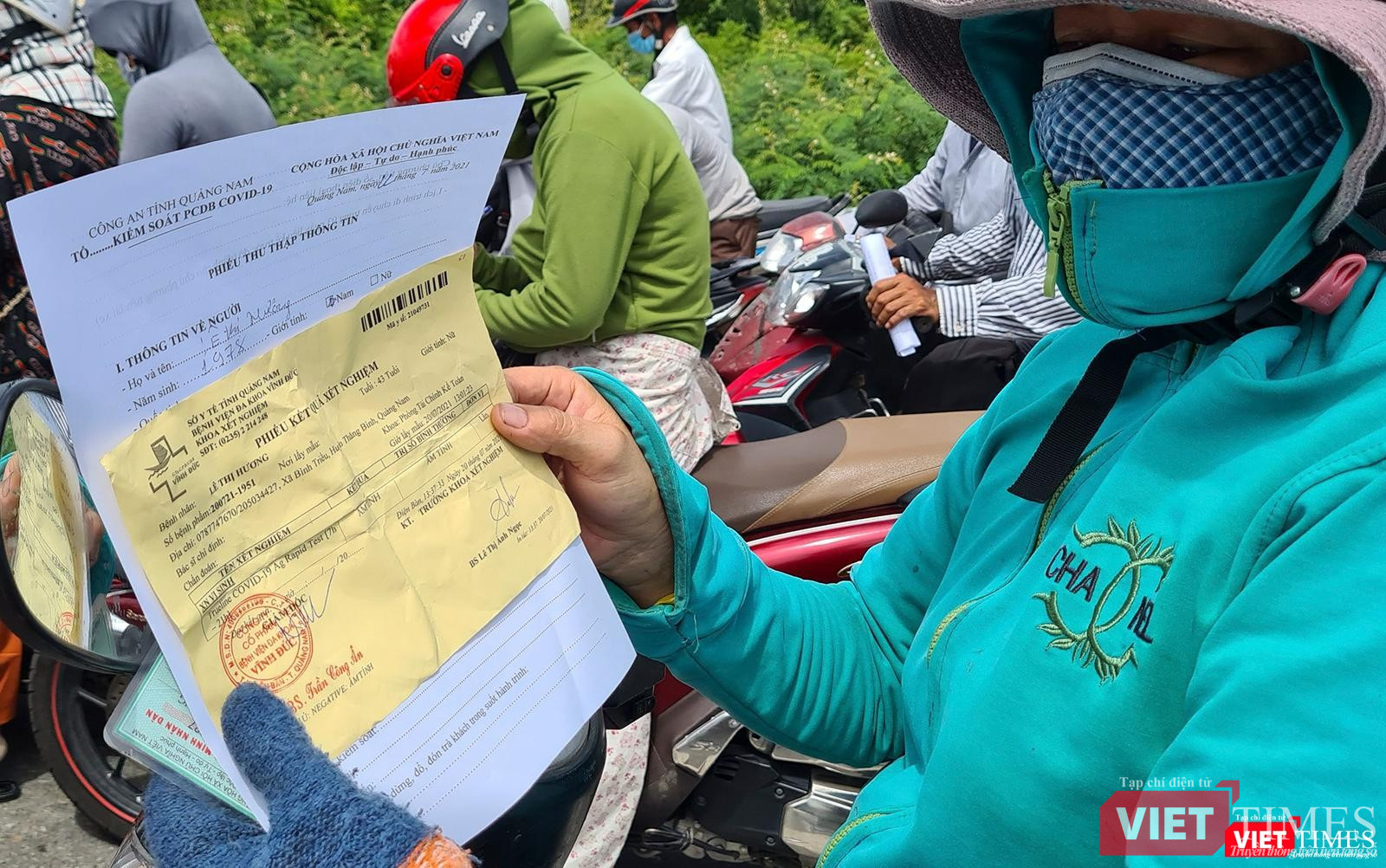 Một người dân trình tờ khai y tế và kết quả xét nghiệm COVID-19 trước khi quan chốt