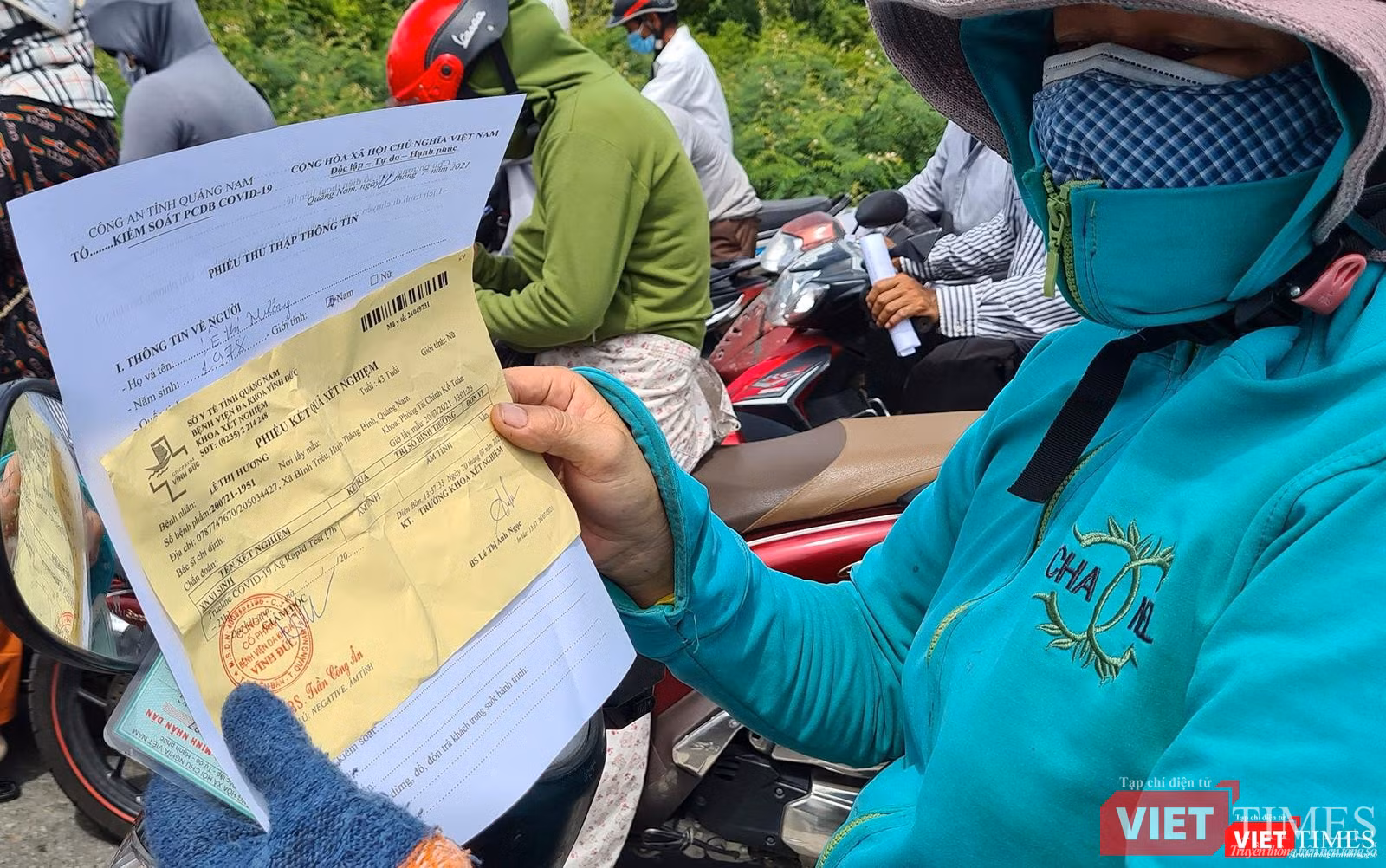 Một người dân trình tờ khai y tế và kết quả xét nghiệm COVID-19 trước khi quan chốt