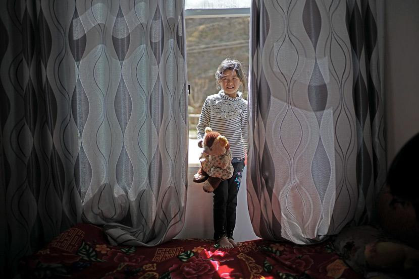 Một đứa trẻ bị bỏ lại chụp ảnh trong phòng ngủ của mình ở làng Lunhe, tỉnh Quý Châu, 2018. Ảnh: People Visual