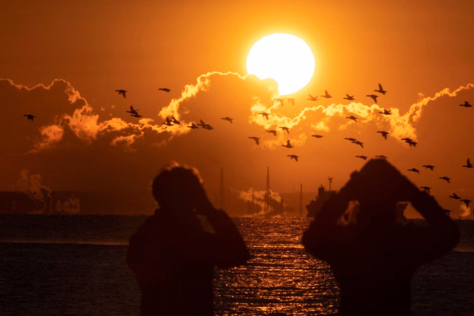 Một cặp đôi ngắm bình minh vào ngày đầu năm mới tại một công viên bên bờ biển ở Tokyo (ảnh: AFP) Một cặp đôi ngắm bình minh vào ngày đầu năm mới tại một công viên bên bờ biển ở Tokyo (ảnh: AFP)