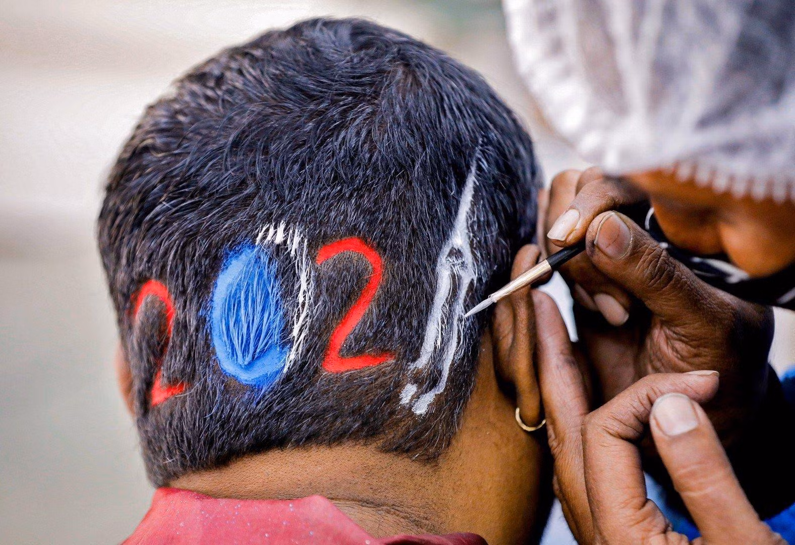 Một thợ cắt tóc tạo hình 2021 cho khách hàng ở Ahmedabad, Ấn Độ (ảnh: Reuters) Một thợ cắt tóc tạo hình 2021 cho khách hàng ở Ahmedabad, Ấn Độ (ảnh: Reuters)