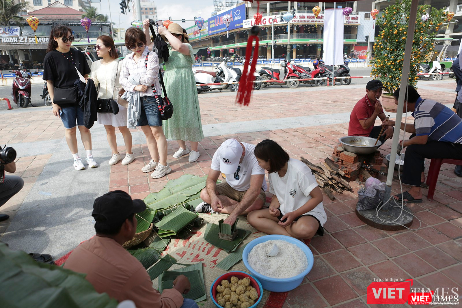 Du khách trải nghiệm gói bánh chưng