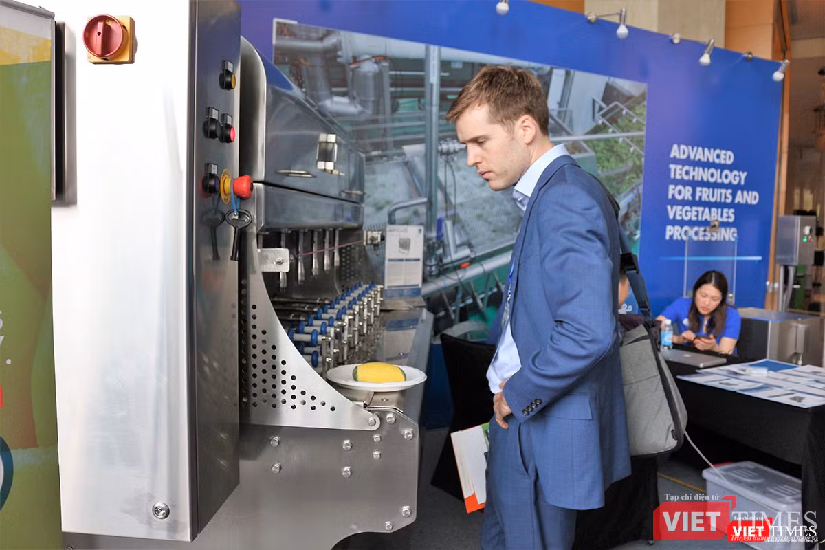 Một khách tham quan tò mò trước chiếc máy gọt hoa quả công nghiệp