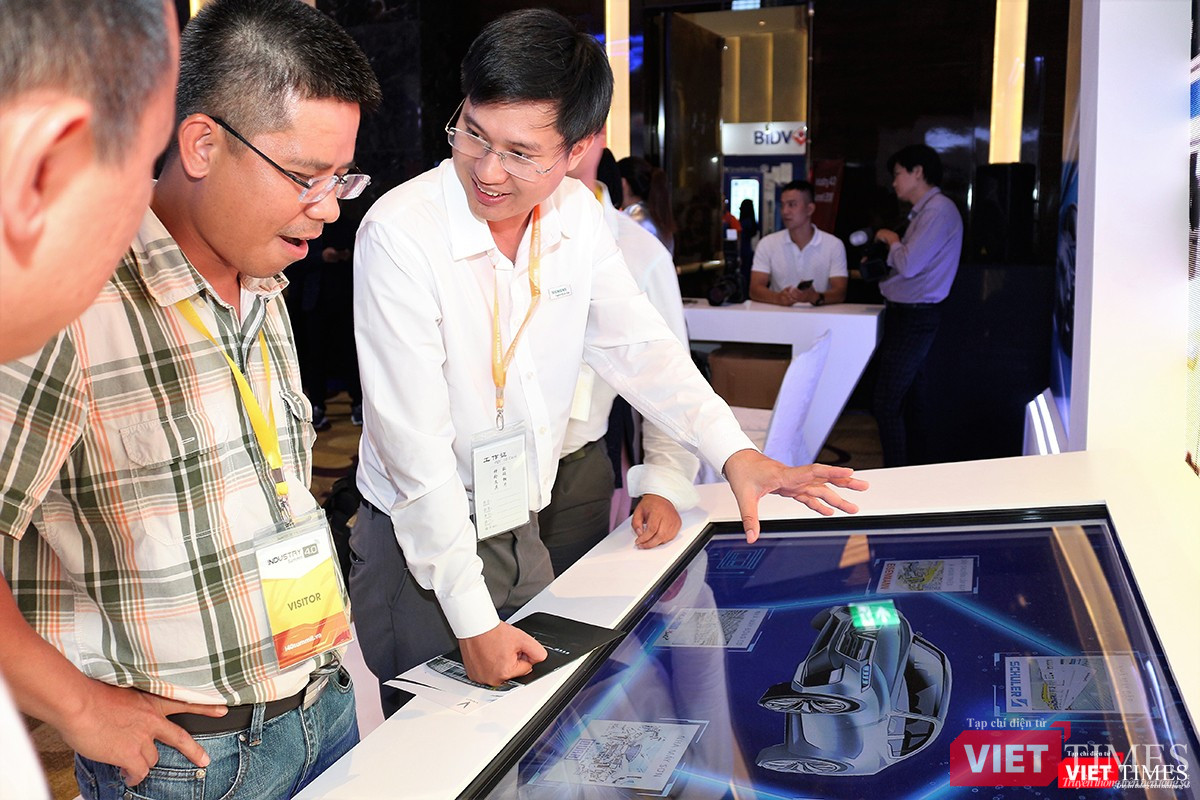 Đại diện VinFast giới thiệu đến khách tham quan triển lãm mẫu xe hơi của hãng