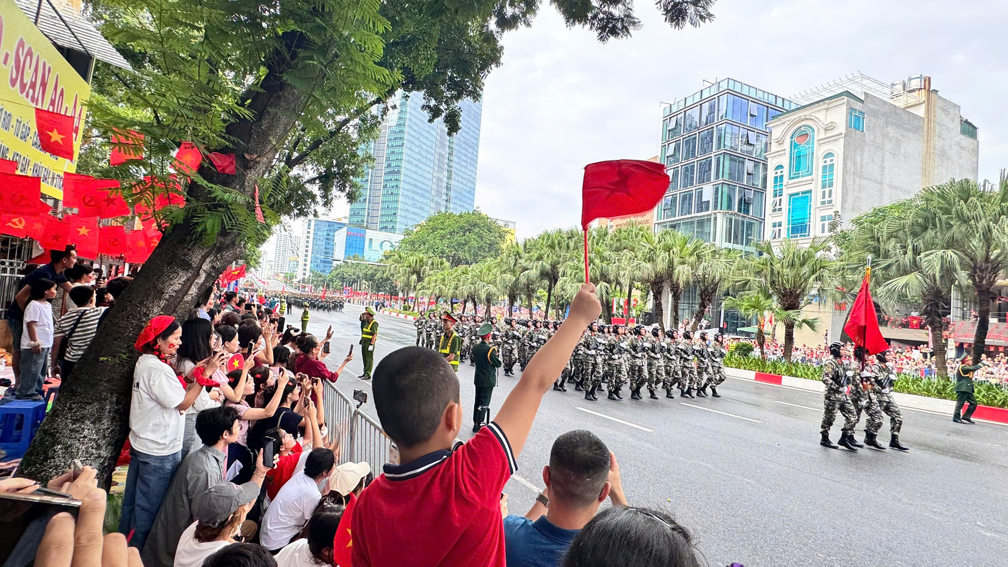 Hai bên đường rợp cờ hoa chào đón các khối diễu binh đi qua. Ảnh: Quỳnh An