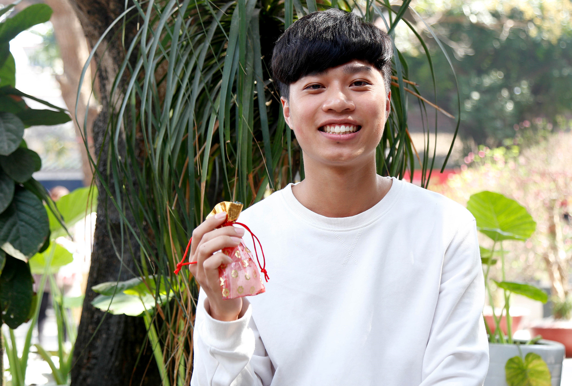 Thịnh (23 tuổi, ĐH Điện Lực) hào hứng khoe chiếc túi vừa mua. Hôm nay là Lễ Tình nhân, nhưng vì chưa có người yêu nên cậu đi cầu duyên một mình. "Hy vọng năm sau mình sẽ có người ấy đi cùng. Mình chẳng đặt tiêu chuẩn cho nửa kia, chỉ mong tìm được người thật lòng và phù hợp với mình mà thôi", Thịnh nói. Nam thanh nu tu den chua Ha xin thoat e tang dot bien vao Valentine hinh anh 8