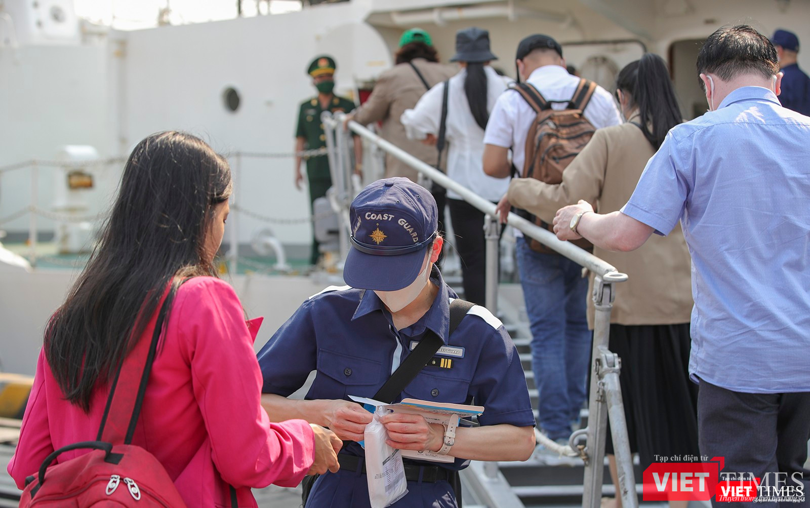 Thuỷ thủ phát khẩu trang cho khách tham quan tàu