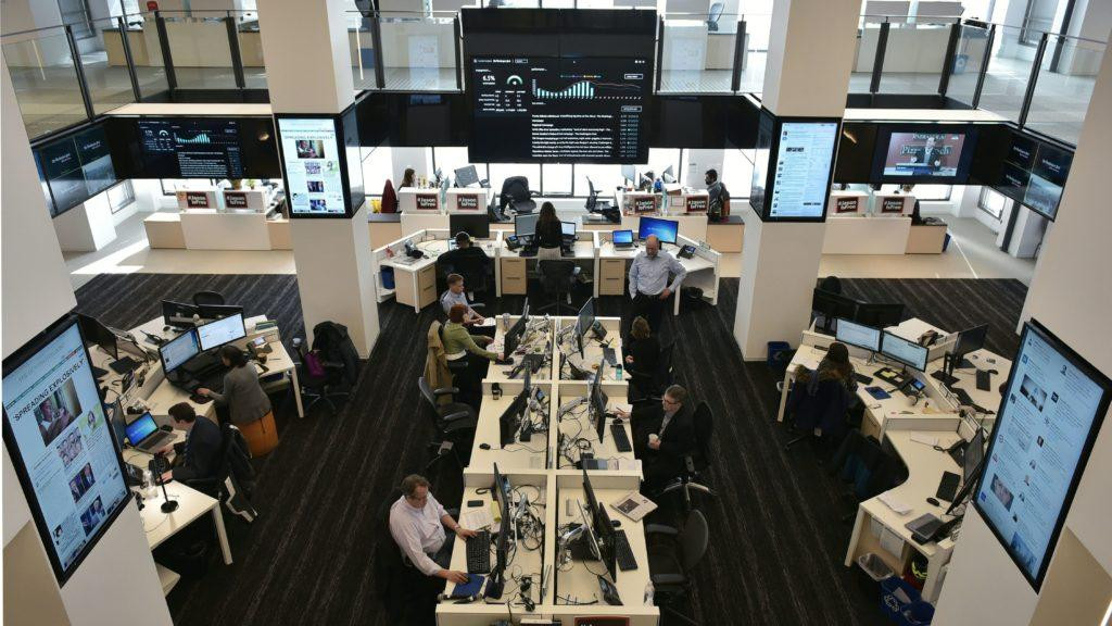 Các nhà báo tại The Washington Post làm việc trong văn phòng được bao quanh bởi màn hình lớn hiển thị trang báo và số lượng người đọc cập nhật Các nhà báo tại The Washington Post làm việc trong văn phòng được bao quanh bởi màn hình lớn hiển thị trang báo và số lượng người đọc cập nhật