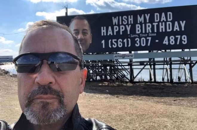 ông Chris bên tấm pa nô có số điện thoại của mình (ảnh: BBC)