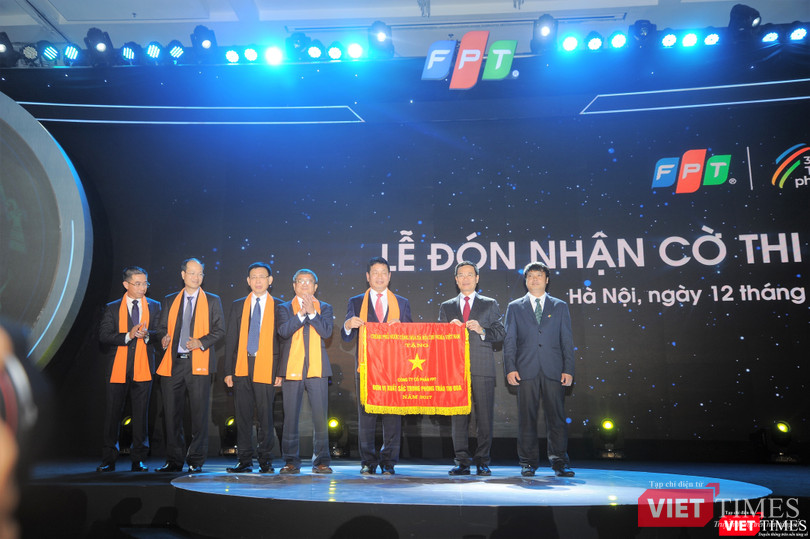 quyền Bộ trưởng Bộ Thông tin Truyền thông Nguyễn Mạnh Hùng thay mặt Chính phủ trao cờ thi đua cho đại diện FPT