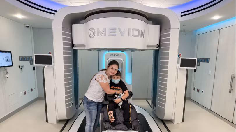 Bé Stephen De La Torre, 7 tuổi, là người đầu tiên được xạ trị bằng “siêu máy” xạ trị Proton tại Mỹ. Ảnh: Phong Lan.