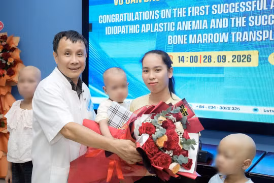 GS Phạm Như Hiệp, Giám đốc Bệnh viện TƯ Huế tặng quà và hoa cho bé gái 4 tuổi suy tủy nhận nguồn cho từ em trai 18 tháng tuổi và ghép tủy thành công. Ảnh Nguyễn Lê.