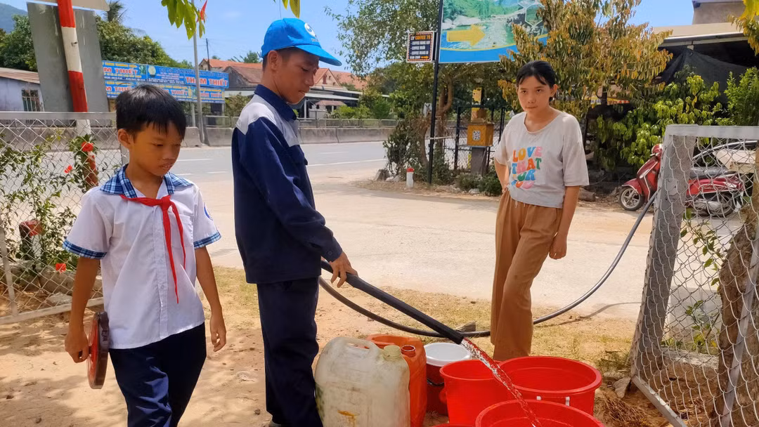 Học sinh ở xã Chân Mây - Lăng Cô tranh thủ ngoài giờ học đi hứng từng xô nước từ xe bồn của HueWACO. Ảnh NL.