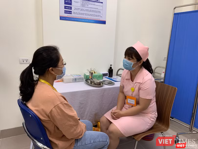 Nhân viên y tế trò chuyện với người tình nguyện trước khi tiêm Nhân viên y tế trò chuyện với người tình nguyện trước khi tiêm