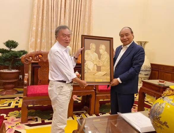 Chủ tịch nước Nguyễn Xuân Phúc (bên phải) tặng quà lưu niệm cho đạo diễn Phạm Việt Tùng tại Văn phòng Chủ tịch nước ngày 4-4-2022 - Ảnh: Đạo diễn Phạm Việt Tùng cung cấp Chủ tịch nước chỉ đạo xem xét phong tặng danh hiệu Anh hùng LLVT cho đại tá Bùi Văn Tùng - Ảnh 2.