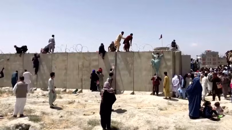 Nhiều người Afghanistan leo qua hàng rào vào trong sân bay để tìm kiếm cơ hội trốn khỏi đất nước (Ảnh: Reuters).