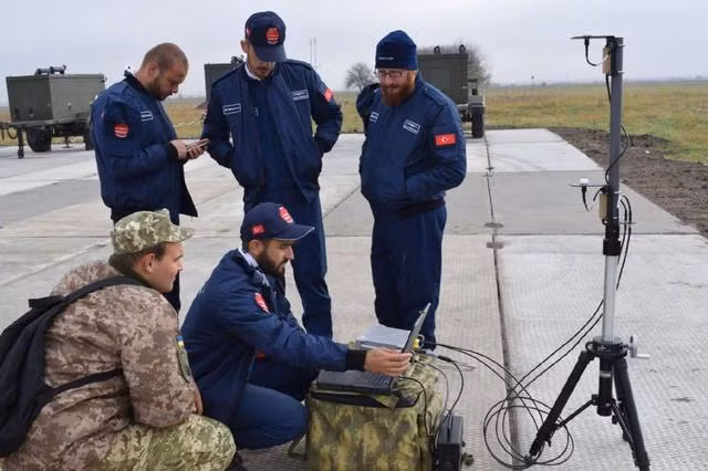Các chuyên gia Thổ Nhĩ Kỳ (áo xanh) hướng dẫn binh sĩ Ukraine điều khiển UAV (Ảnh: kknews). Các chuyên gia Thổ Nhĩ Kỳ (áo xanh) hướng dẫn binh sĩ Ukraine điều khiển UAV (Ảnh: kknews).