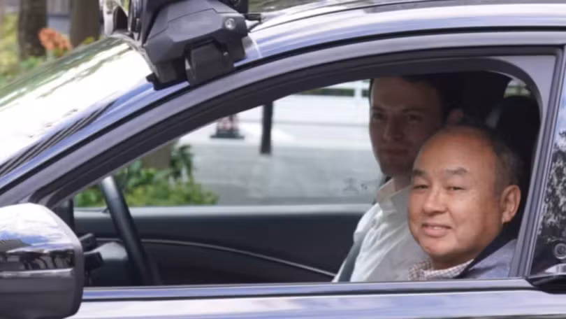 Chủ tịch kiêm Tổng giám đốc điều hành Tập đoàn SoftBank Masayoshi Son ngồi cạnh Tổng giám đốc điều hành Wayve Alex Kendall trên chiếc xe tự lái ở Tokyo. Ảnh: Nikkei Asia.