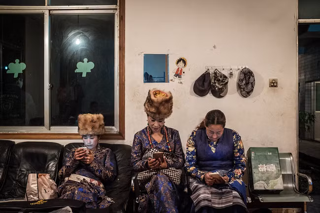 Hình 7: Những người phụ nữ Tây Tạng đang ngồi chờ tham dự một bữa tiệc do Kun tổ chức nhằm ăn mừng việc mở rộng và nâng cấp máy đào Bitcoin.