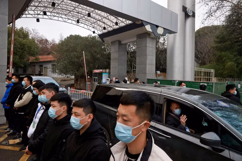 Các nhân viên an ninh làm thành hàng rào bao quanh đoàn chuyên gia WHO (Ảnh: Reuters).