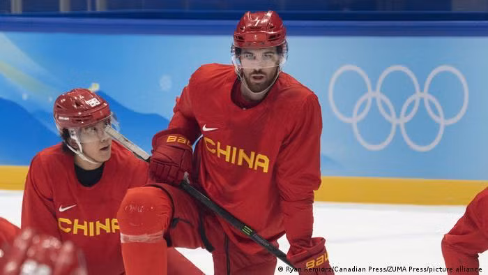 Jake Chelios (phải) cầu thủ Hockey trên băng Mỹ nhập tịch thi đấu cho đội tuyển Trung Quốc (Ảnh: Deutsche Welle). Jake Chelios (phải) cầu thủ Hockey trên băng Mỹ nhập tịch thi đấu cho đội tuyển Trung Quốc (Ảnh: Deutsche Welle).