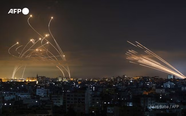 Tên lửa của Hamas bắn sang Israel (phải) và hệ thống Vòm Sắt tiến hành đánh chặn (trái ảnh) Ảnh: AFP.