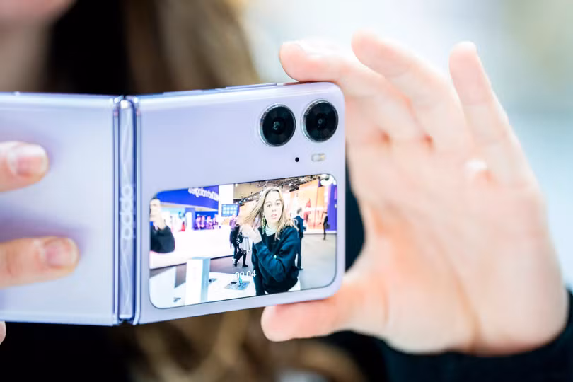 Khách hàng kiểm tra điện thoại thông minh Oppo Find N2 Flip trong Đại hội Thế giới Di động ở Barcelona vào ngày 1/3. Ảnh: AP Photo Khách hàng kiểm tra điện thoại thông minh Oppo Find N2 Flip trong Đại hội Thế giới Di động ở Barcelona vào ngày 1/3. Ảnh: AP Photo