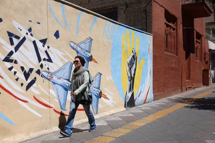 Người dân Iran đi bộ qua bức tranh tường cổ động ở Tehran, Iran. Ảnh: Reuters.