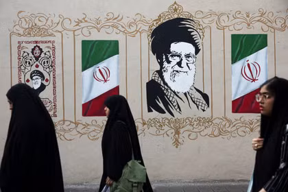 Người dân đi bộ ngang qua bức tranh tường mô tả cố lãnh đạo tối cao của Iran, Ayatollah Ali Khamenei, trên một con phố ở Tehran, Iran, ngày 13/8. Ảnh: Reuters.