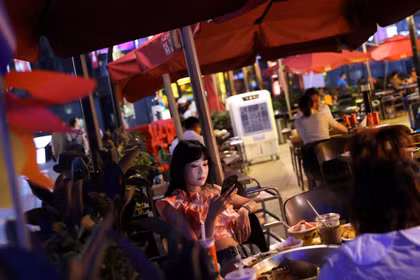Khách hàng dùng bữa tại một nhà hàng trong khu mua sắm ở Bắc Kinh, Trung Quốc, ngày 25/7/2022. Ảnh: Reuters.