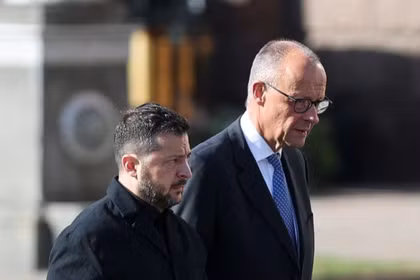 Tổng thống Ukraine Volodymyr Zelensky và Thủ tướng Đức Friedrich Merz cùng nhau đi bộ và đặt vòng hoa tưởng niệm các chiến sĩ Ukraine hy sinh, tại Quảng trường Độc lập ở Kiev, Ukraine, ngày 4/10. Ảnh: Reuters.