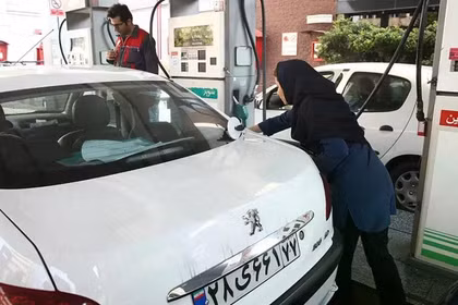 Một người phụ nữ đổ đầy bình xăng xe tại một trạm xăng sau khi giá nhiên liệu tăng ở Tehran, Iran, ngày 15/11/2019. Ảnh: Reuters.