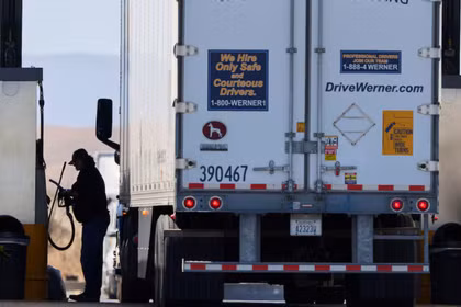Một tài xế vận hành máy bơm nhiên liệu diesel tại trạm dừng xe tải ở Dunnigan, California, Mỹ, ngày 28/9. Ảnh: Reuters.