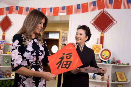 Đệ nhất phu nhân Mỹ Melania Trump và đệ nhất phu nhân Trung Quốc Bành Lệ Viện cùng giơ cao bức thư pháp chữ Hán có nghĩa "vận may" do các em học sinh viết trong chuyến thăm trường tiểu học Banchang ở Bắc Kinh vào tháng 11/2017. Ảnh: Reuters.