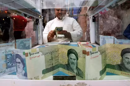 Một người đàn ông đang đếm tiền rial của Iran tại một cửa hàng đổi tiền, trước khi lệnh trừng phạt của Mỹ đối với Tehran bắt đầu có hiệu lực, ở Basra, Iraq, ngày 3/11/2018. Ảnh: Reuters.