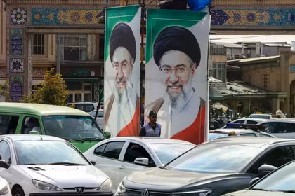 Một sĩ quan cảnh sát điều tiết giao thông khi đứng dưới chân dung của Lãnh đạo tối cao Iran Mojtaba Khamenei ở Tehran vào ngày 21/10. Ảnh: AFP.