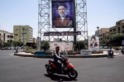 Người dân đi xe ngang qua một biểu ngữ có hình ảnh Lãnh tụ tối cao của Iran, Mojtaba Khamenei, tại Tehran, Iran, ngày 28/6. Ảnh: Reuters.
