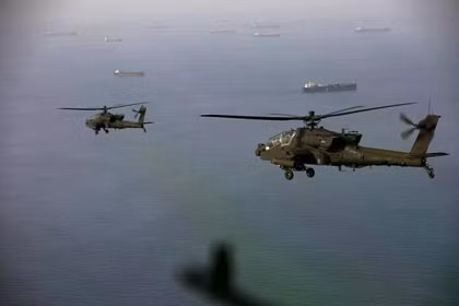 Máy bay trực thăng AH-64 Apache bay phía trên eo biển Hormuz trong một cuộc tuần tra vào ngày 17/4. Ảnh: AFP.