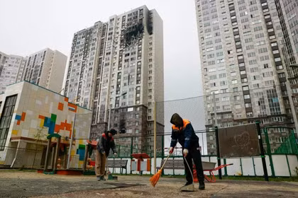 Ngày 20/9, các công nhân ở Kotelniki thuộc vùng Moscow dọn dẹp đống đổ nát gần một tòa nhà chung cư cao tầng bị hư hại do vụ tấn công bằng máy bay không người lái của Ukraine. Ảnh: Reuters.