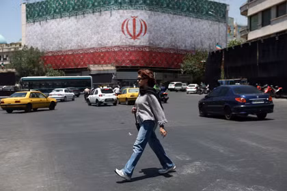 Một người phụ nữ đi bộ trên đường phố ở Tehran, Iran, ngày 14/6. Ảnh: Reuters.