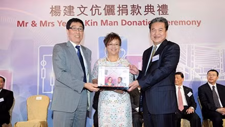 Yeung Kin-man (phải) nhận quà lưu niệm trong một buổi từ thiện. Ảnh: Bloomberg.
