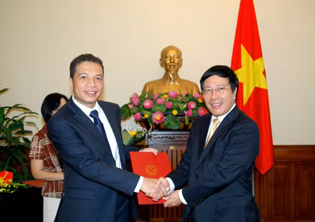 Phó Thủ tướng Chính phủ, Bộ trưởng Ngoại giao Phạm Bình Minh trao Quyết định cho ông Đặng Minh Khôi. Ảnh: Quang Hòa/TG&VN