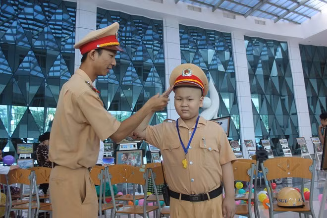 Bé Đỗ Tuấn Dũng thực hiện hiệu lệnh theo hướng dẫn của cán bộ CSGT.