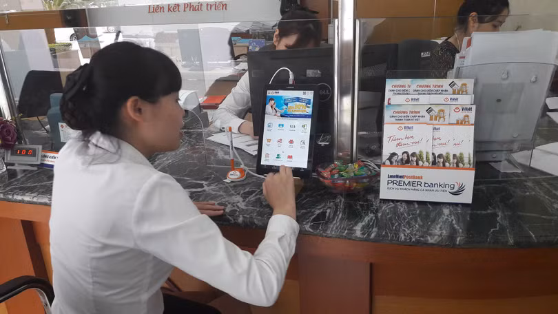 Nhân viên LienVietPostBank đang thực hành sử dụng máy tính bảng để giới thiệu cho khách hàng