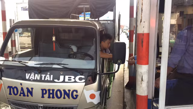 ... sau đó anh này tiếp tục đi vào trạm, tắt máy xe và đếm từng tờ tiền lẻ để mua vé.