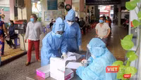 Bàn tiếp nhận phiếu ghi lấy mẫu luôn tất bật. Tất cả chỉ còn chung một màu áo xanh bảo hộ. của ngành Y. Ảnh: GVT.