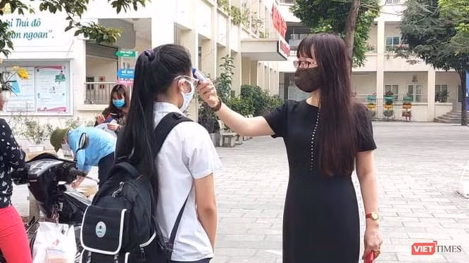 Cô giáo đo nhiệt độ cho học sinh (Ảnh- Minh Thuý) 